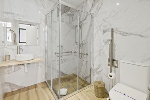 Une salle de bain moderne avec une douche à parois de verre, un lavabo et des toilettes.