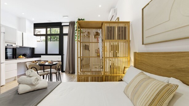 Et moderne hotelværelse med seng, spiseplads og tekøkken.