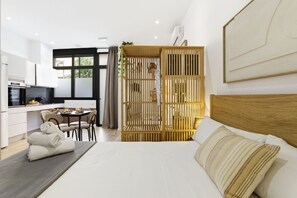 Une chambre d’hôtel moderne équipée d’un lit, d’un coin repas et d’une kitchenette.