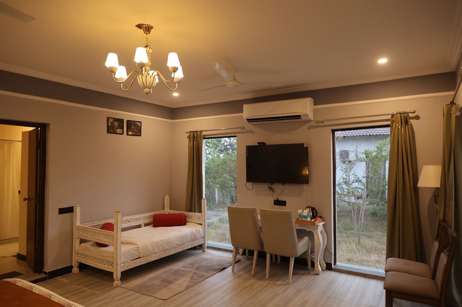 Une chambre à coucher comprenant un lit, un bureau, des chaises, un téléviseur et un appareil de climatisation.