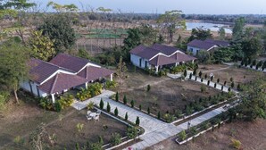 Un quartier résidentiel avec des maisons, un chemin piétonnier pavé et une étendue d’eau en arrière-plan.