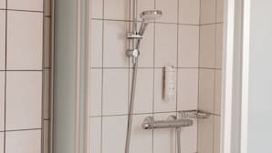 A shower with a handheld showerhead and a wall-mounted faucet. - Hotel Casa56 (Weiswampach)