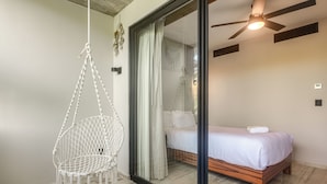 A bedroom with a bed, a hanging chair, a ceiling fan, and a sliding glass door. - 3 Mi to Beach! Tranquil Tulum Oasis w/ Balcony (Tulum)