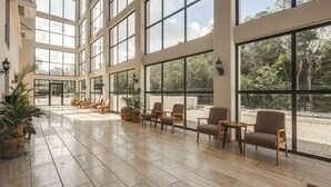 A spacious lobby with large windows, wooden flooring, and several seating areas. - 3 Mi to Beach! Tranquil Tulum Oasis w/ Balcony (Tulum)