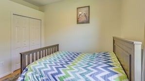 A bedroom with a bed, a ceiling fan, a door, and a wall-mounted picture. - Extended Stay in Tampa Area! Spacious Home w/ Yard (Riverview)