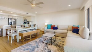 A modern living room with a sofa, a coffee table, and a dining area with a table and chairs. - Sweeping View, Luxe Perks: Suntide III - Unit 708 (South Padre Island)