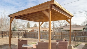A covered outdoor patio with wicker furniture and a table. - Family Friendly! Spacious Lakewood Haven w/ Yard (Lakewood)