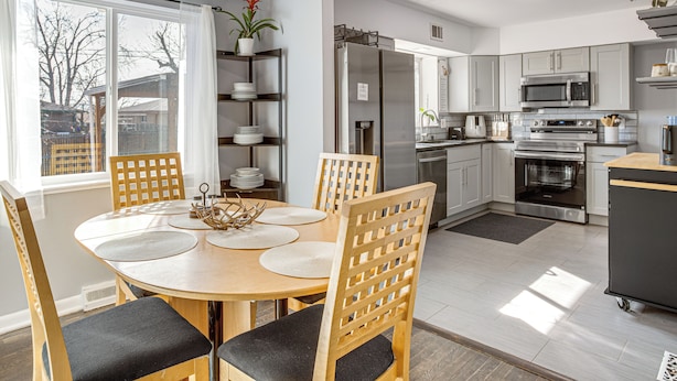 A modern kitchen with a dining area, featuring a round table, chairs, and built-in appliances. - Family Friendly! Spacious Lakewood Haven w/ Yard (Lakewood)
