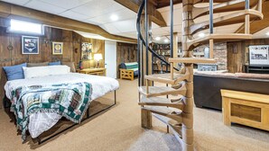 Une chambre à coucher avec un lit, un escalier en colimaçon en bois et une table de chevet.