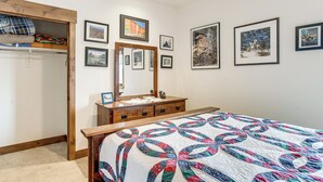 Ein Schlafzimmer mit einem Bett, einem Schminktisch, einem Spiegel und einem Kleiderschrank.