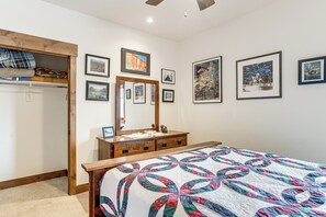 A bedroom with a bed, a dresser, a mirror, and a wardrobe.