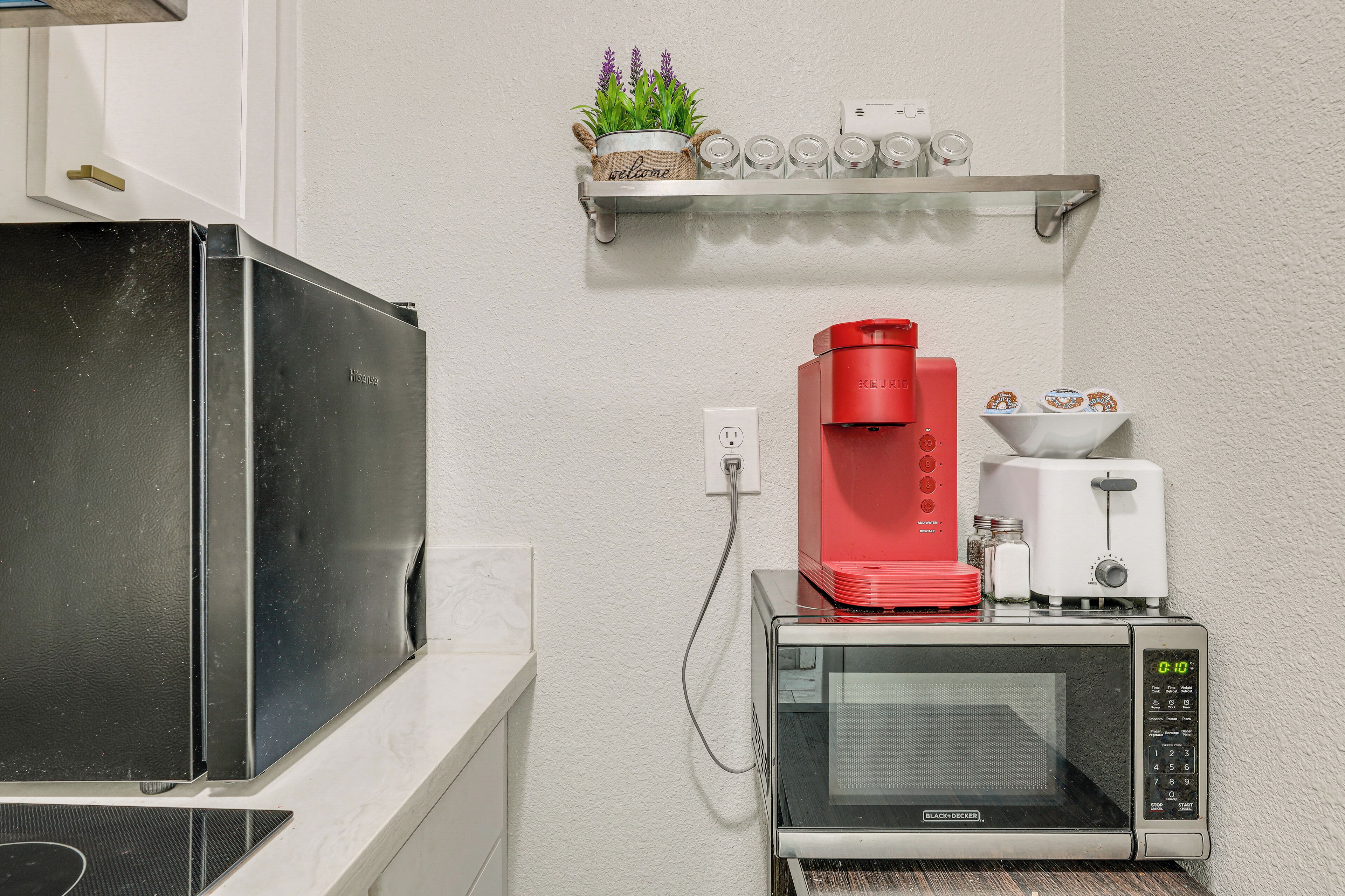 Et tekøkken med mikrobølgeovn, kaffemaskine og brødrister.