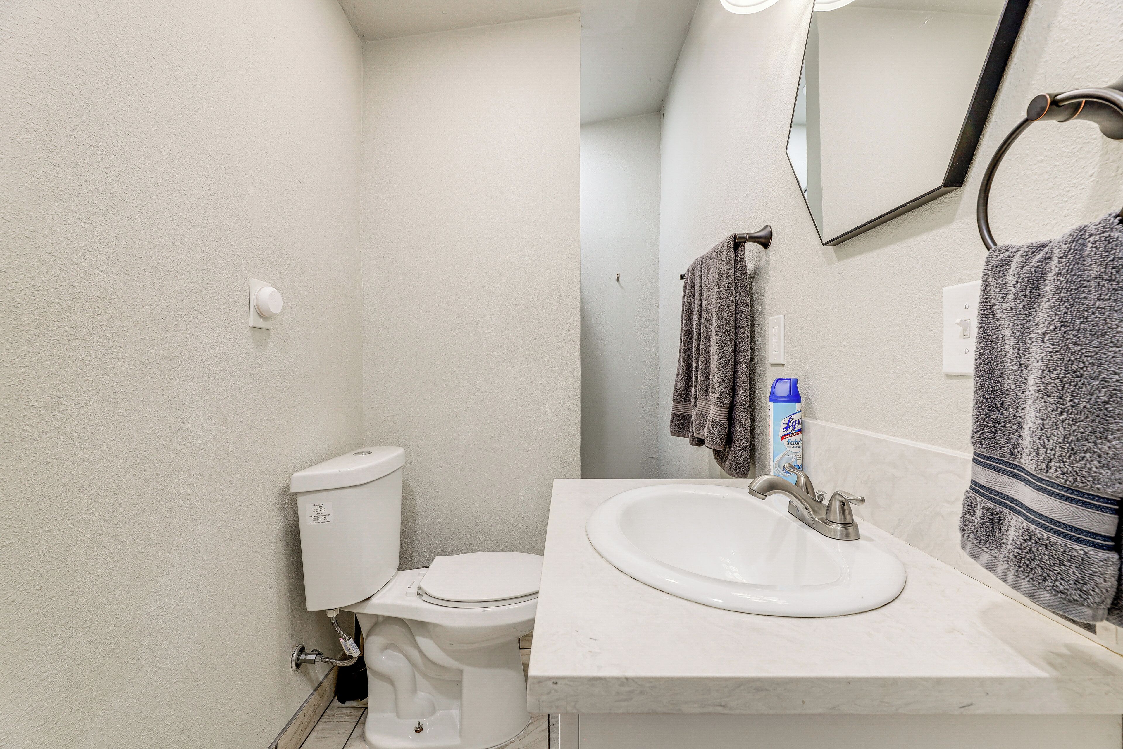 A bathroom with a toilet, sink, and towel rack.