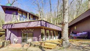 A two-story house with a purple exterior, large windows, and a wooden deck. - Walk to Beaver Lake! 'the Cavehouse' w/ 4 Decks (Garfield)