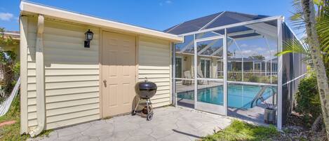 A house with a covered pool, a barbecue grill, and a glass-enclosed patio area.