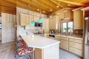 A kitchen with a large island, wooden ceiling, and pendant lights. - The Boat House w/ Dock: Enjoy Lake Life! (Syracuse)