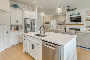 A modern kitchen with white cabinetry, stainless steel appliances, and pendant lighting. - Northern Grand Strand! New-build Home w/ Patio (Loris)