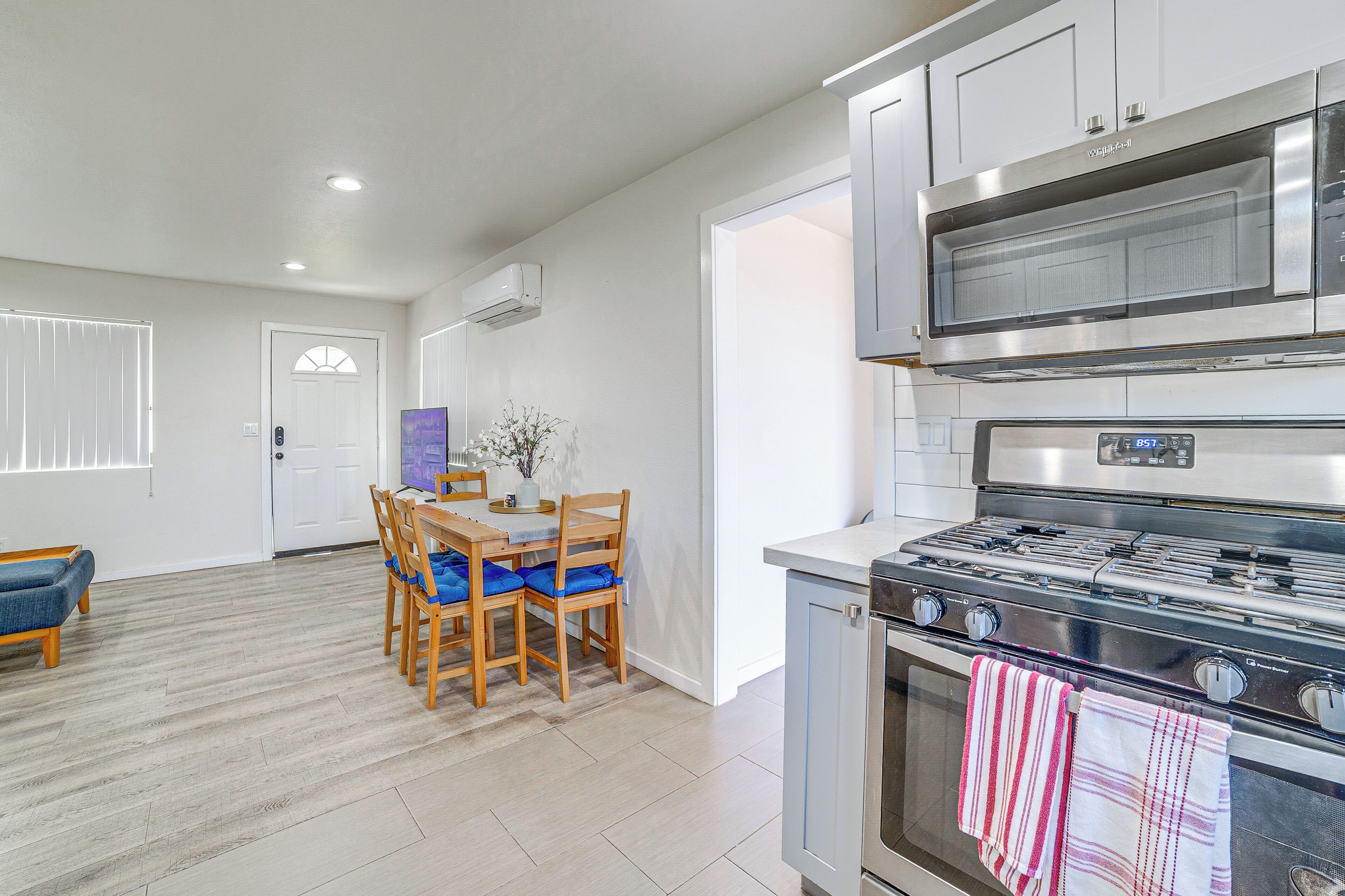A modern kitchen with a stove, oven, and microwave. There is a dining area with a table and chairs.