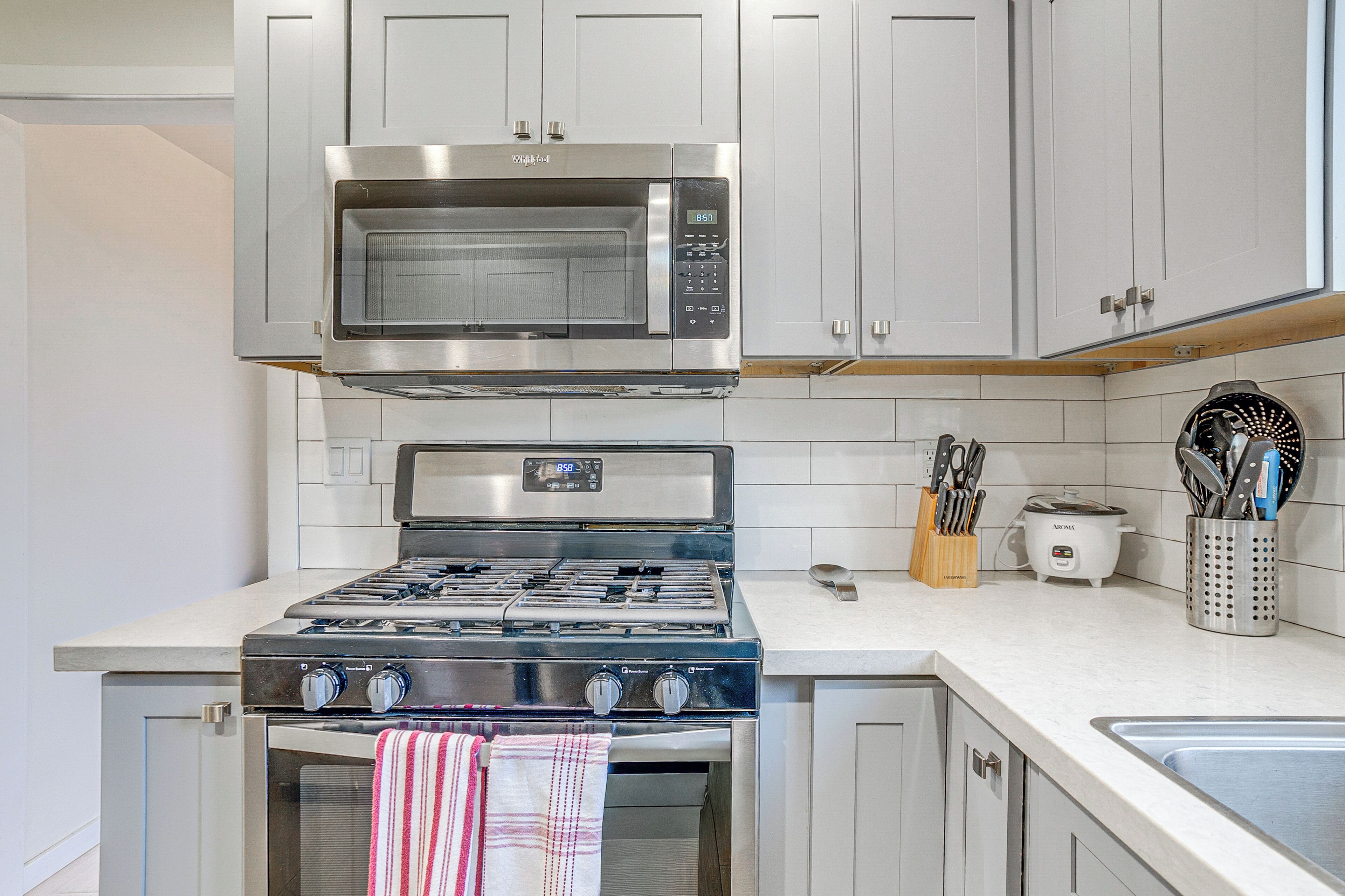 Una cocina equipada con estufa, horno, microondas y tostadora de acero inoxidable.