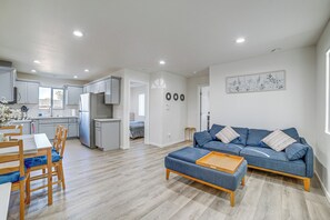 A modern apartment with a dining area, kitchenette, living room with a sofa, and a view of the outside. - 2 Mi to Dtwn Glendora! Pet-friendly Extended Stay (Glendora)