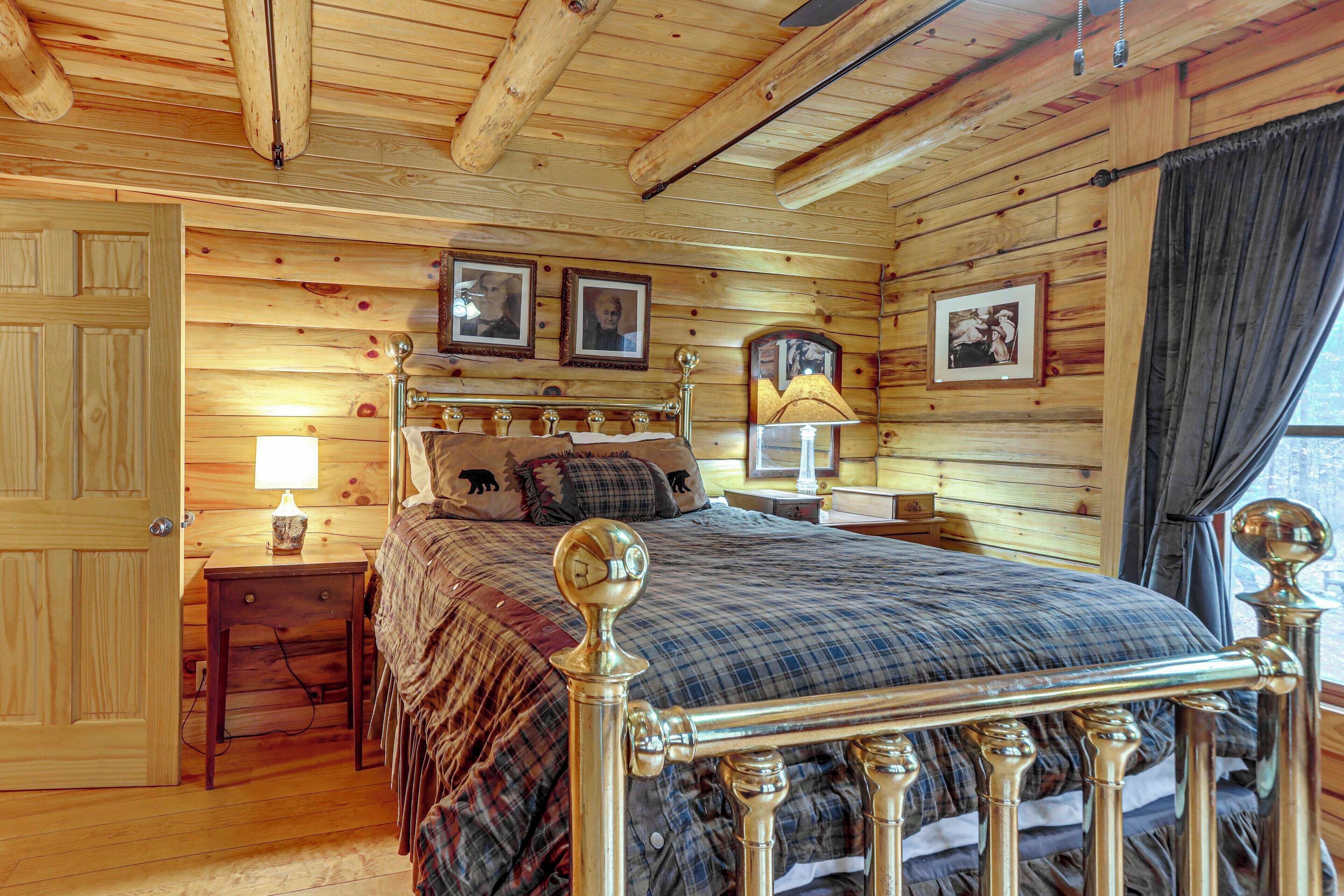 Ein Schlafzimmer mit Holzwänden, einem Bett, Nachttischen und gerahmten Bildern an der Wand.