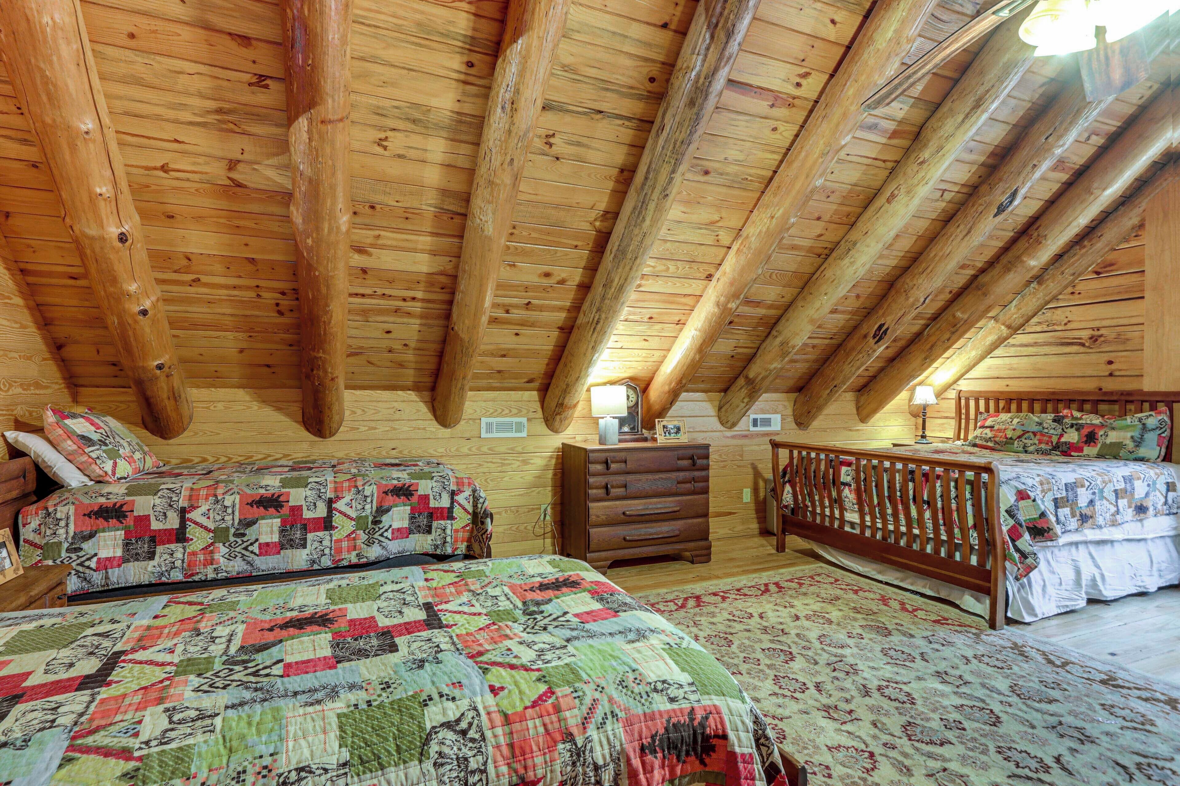 Un dormitorio con vigas de madera, dos camas con colchas, un aparador y una mesita de noche.
