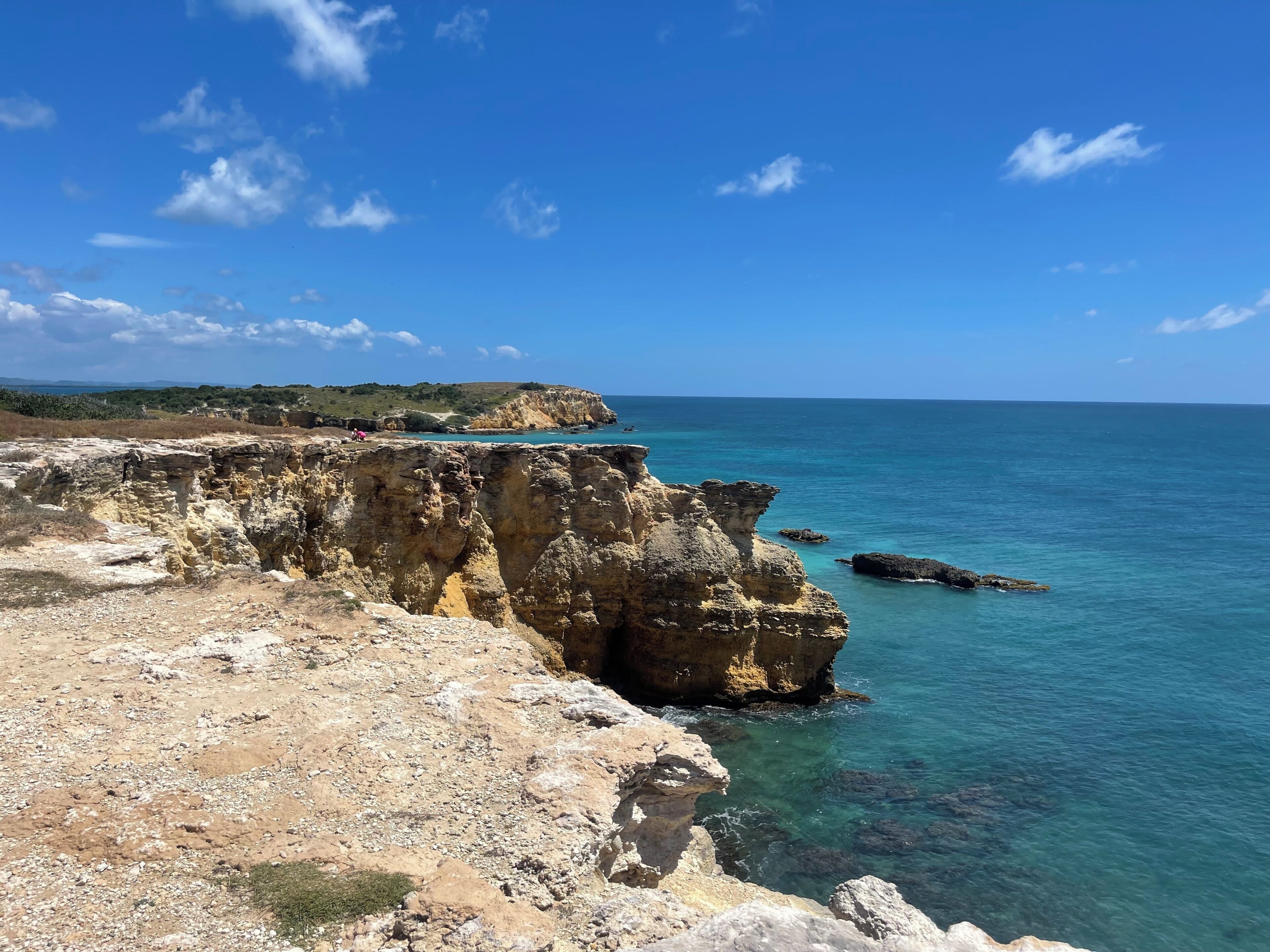 Eine Küstenlandschaft mit schroffen Klippen und klarem, blauem Meer.