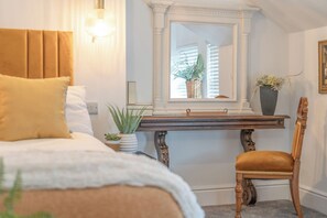 Une chambre à coucher comprenant un lit, une table de chevet, une chaise et une fenêtre donnant sur l’extérieur.