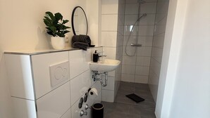 A modern bathroom with a toilet, sink, and shower. - Simon Living - Apartment Pyramide central and quiet location in Karlsruhe (Karlsruhe)