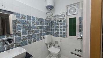 A bathroom with a white sink, toilet, and shower.