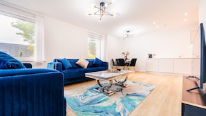 A modern living room with a blue sofa, a coffee table, and a marble rug. - LUX Riverside Duplex Masionette By LCY Excel (London)