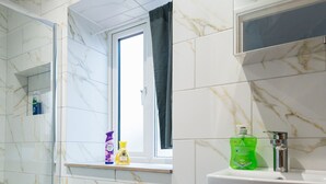Ein Badezimmer mit Toilette, Bidet, Waschbecken und Fenster.