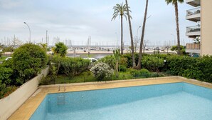 Ein Swimmingpool mit Blick auf das Meer und Palmen.