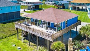 A two-story house with a balcony, a covered patio, and a view of the ocean. - Crystal Blue - 2nd Row - Easy Beach access, fenced yard, steps to the beach! (Crystal Beach)