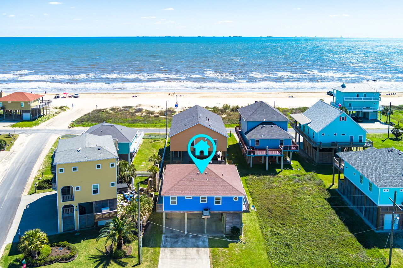 Une zone résidentielle côtière comprenant des maisons, une plage et une route.