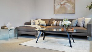 A modern living room with a sofa, a glass coffee table, and a minimalist decor. - Hertford Flat 14 (London)