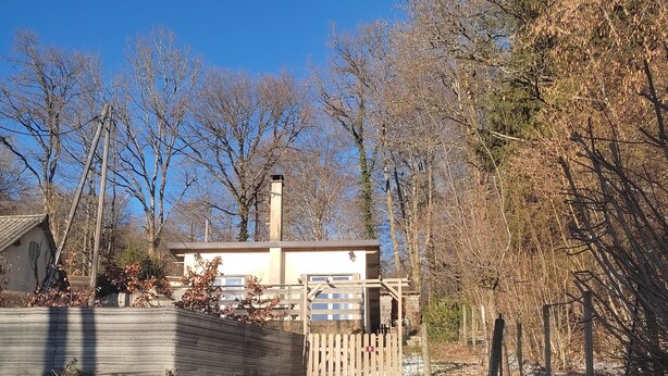 A house with a wooden staircase leading to a gated entrance, surrounded by leaf-covered ground and trees. - Cottage 200 m from Lac des Settons (Montsauche-les-Settons)