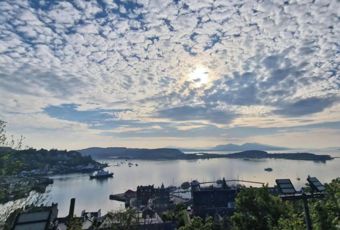 A coastal town with boats, a calm sea, and a clear sky.