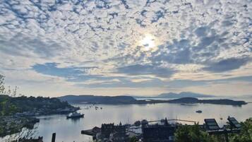 A coastal town with boats, a calm sea, and a clear sky.