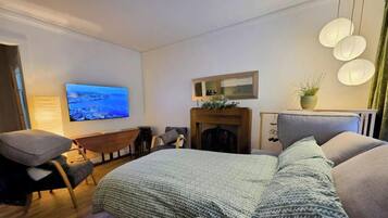 Un dormitorio moderno con cama, televisión, chimenea y zona de estar.