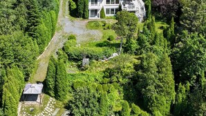 An aerial view of a two-story house surrounded by dense forest and a lake. - L`échappée du Lac-Saint-Jean (Lac-Saint-Jean-Est Regional County Municipality)