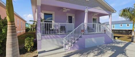 A single-story house with a porch, a white railing, and a number '624' on the wall.