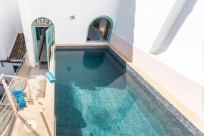 Ein kleiner, sauberer Swimmingpool mit einer Holzterrasse und einem Handtuchhalter.