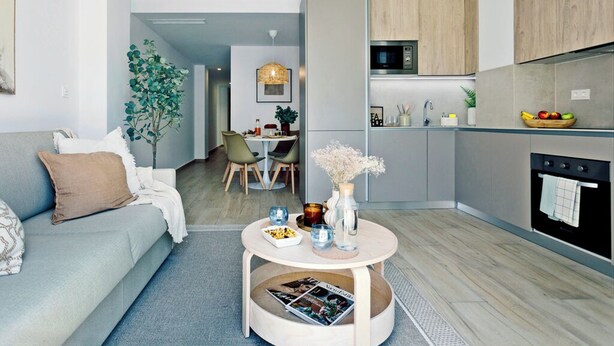 A modern living room with a sofa, coffee table, and a dining area with chairs. - REM II Torrevieja (Torrevieja)