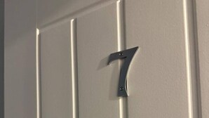Una puerta con un pomo metálico con el número 7.