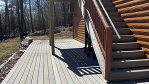 A wooden deck leading to a cabin with a staircase and a covered porch. - The Yodeling Loon Hideaway | Sandy Swimming | Dock and Lakefront Fun (Cable)