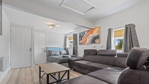 A modern living room with a sofa, a table, and a bed. - Bella`s Lodge - near Motor Point Arena (Nottingham)