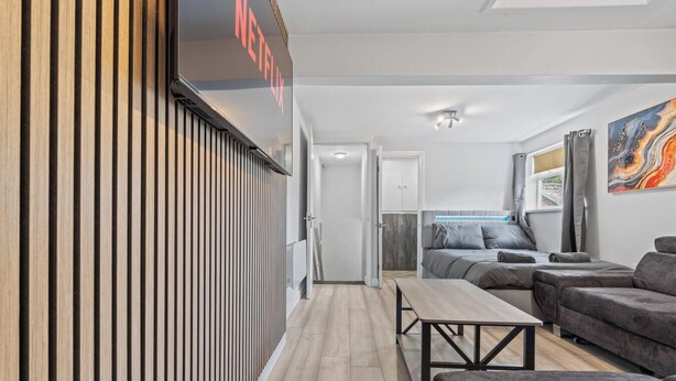A modern living room with a sofa, a coffee table, and a TV mounted on a wall. - Bella`s Lodge - near Motor Point Arena (Nottingham)