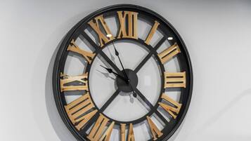 Une horloge murale ronde, dotée de chiffres romains et d’un design minimaliste.