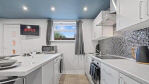 A compact kitchen with a washing machine, a microwave, and a sink. - Bella`s Lodge - near Motor Point Arena (Nottingham)